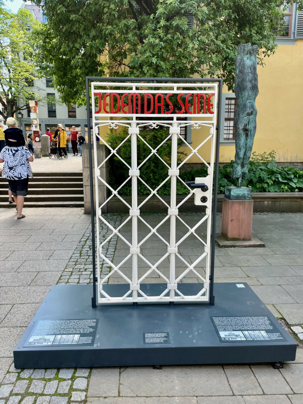 Vor dem Schiller-Museum steht eine Kopie des Eingangstors vom KZ Buchenwald mit dem Schriftzug „Jedem das Seine“, gestaltet 1935 vom Bauhäusler Franz Ehrlich. Im Hintergrund Wieland Försters 1988 aufgestellte Skulptur Hommage à Schiller Foto: Jörg Restorff